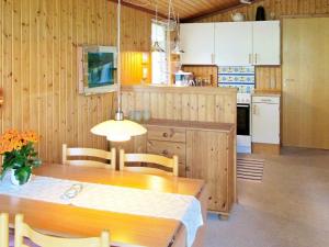 een keuken met een houten tafel en een eetkamer bij 5 person holiday home in R dby in Rødby