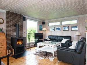 a living room with a couch and a fireplace at 6 person holiday home in Knebel in Knebel