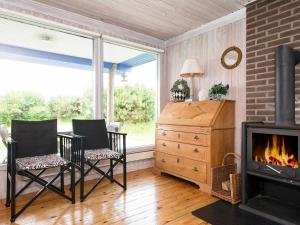 a living room with two chairs and a fireplace at 6 person holiday home in Knebel in Knebel