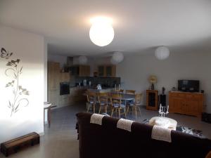 a living room and kitchen with a couch and a table at Gite Le Petit Pied-à-Terre in La Chapelle-Saint-Sauveur