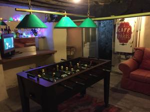 a foosball table in a living room with green lights at Cynfaen house in Corwen