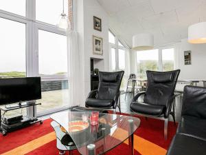 een woonkamer met stoelen en een glazen tafel bij 10 person holiday home in L kken in Løkken