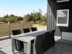 einen Tisch und Stühle auf der Terrasse eines Hauses in der Unterkunft 10 person holiday home in Harbo re in Harboør