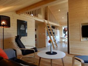 a living room with a staircase and a table at Schwarzes Holzferienhaus mit Sauna -- GARTENGLÜCK -- an der Ostsee, Zierow bei Wismar, Strand 500m, 2 Schlafzimmer in Zierow