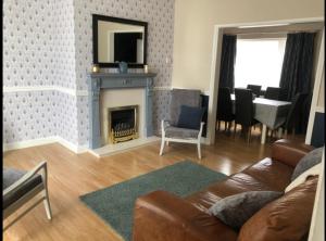 a living room with a couch and a fireplace at Bea's Cottage in Newbiggin-by-the-Sea