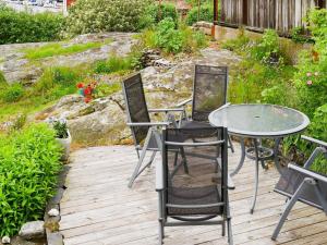 a patio with a table and chairs on a wooden deck at 4 person holiday home in R nn ng in Rönnäng