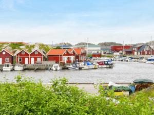 a group of boats docked in a marina with houses at 4 person holiday home in R nn ng in Rönnäng