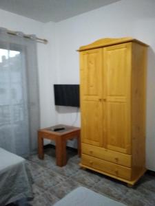 1 dormitorio con armario de madera y mesa en Apartamento Bello Bello, en Valle Gran Rey