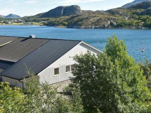 un edificio bianco accanto a un grande bacino d'acqua di Holiday Home Steinvik a Oksvoll