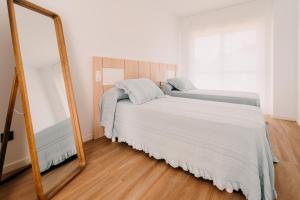 Posteľ alebo postele v izbe v ubytovaní Apartamentos Rúa Vella