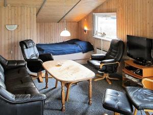 uma sala de estar com uma cama, uma mesa e cadeiras em 8 person holiday home in Stege em Stege