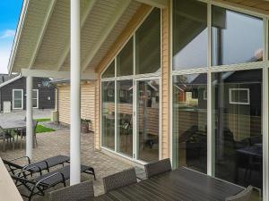 a screened porch with glass doors and a table and chairs at 10 person holiday home in Hasselberg in Kappeln