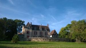 an old house with a fence in the grass at Château Logis de Roche in Clairac