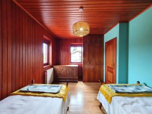 a room with two beds and a wooden ceiling at Casa de Castro Laboreiro in Castro Laboreiro