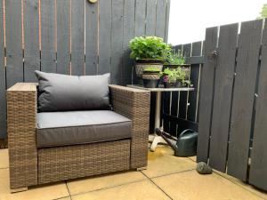 a wicker chair sitting on a patio with potted plants at Brada View Bamburgh in Bamburgh