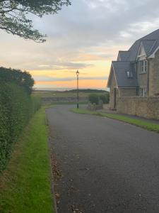 a road leading to a house with a street light at Brada View Bamburgh in Bamburgh