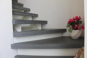 a vase with red flowers sitting on a shelf at Le case di Carlotta & Giorgia in Pozzillo