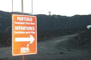 an orange sign on a dirt road with an arrow at Le case di Carlotta & Giorgia in Pozzillo