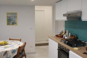 a kitchen with white cabinets and a table with a plate of food at Le case di Carlotta & Giorgia in Pozzillo