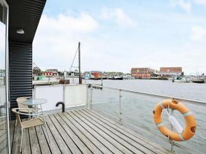 una terraza de madera con una mesa y un salvavidas en un barco en 6 person holiday home in Hemmet, en Falen