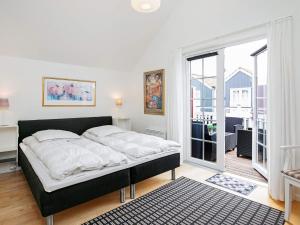een slaapkamer met een bed en een groot raam bij 6 person holiday home in Bl vand in Blåvand