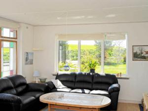 sala de estar con sofá de cuero negro y mesa en 10 person holiday home in Nordborg, en Nordborg