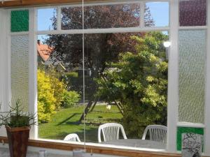 ventana con 2 sillas blancas y vistas a un patio en 10 person holiday home in Nordborg, en Nordborg