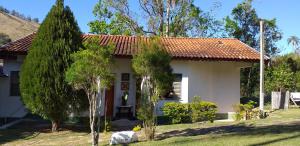 a small white house with a red roof at Chalé e Camping Daragona 1 in Águas de Lindóia