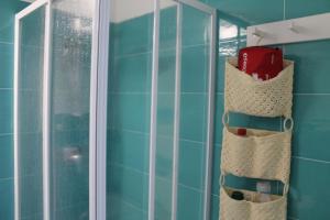 a bathroom with blue tiled walls and a glass shower at Le case di Carlotta & Giorgia in Pozzillo