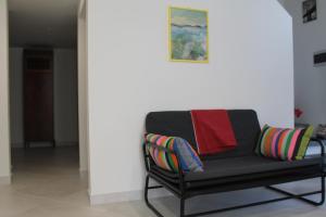 a black bench with colorful pillows on it in a room at Le case di Carlotta & Giorgia in Pozzillo