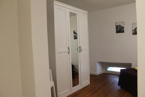 a white cabinet with a mirror in a room at Le case di Carlotta & Giorgia in Pozzillo
