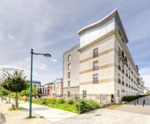 a building with a street light in front of it at Studio Art - Shopping center and train station 500m - Disneyland Paris 5min in Montévrain