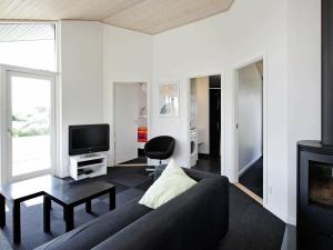 a living room with a couch and a tv at 8 person holiday home in Haderslev in Årøsund