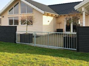 a fence in front of a house at 18 person holiday home in Bogense in Bogense