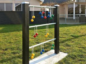 a swing set with balls on it in a yard at 18 person holiday home in Bogense in Bogense