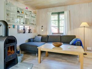 a living room with a couch and a wood stove at 6 person holiday home in Nex in Snogebæk