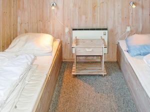 a room with two beds and a night stand with a table at Holiday home Idestrup in Marielyst