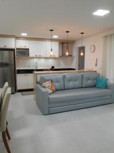 uma sala de estar com um sofá azul numa cozinha em Apartamento com vista pro mar próximo ao Beto Carrero em Penha