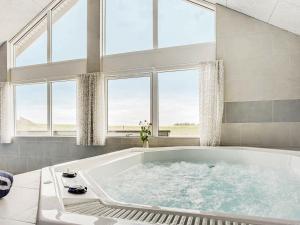 een groot bad in een kamer met ramen bij 30 person holiday home in Bogense in Bogense