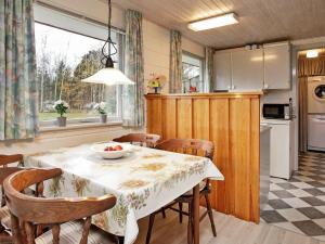 a kitchen and dining room with a table and chairs at 4 person holiday home in L s in Læsø