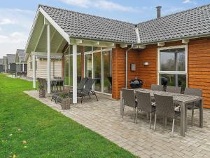 a patio with a table and chairs in front of a house at 10 person holiday home in Hasselberg in Kappeln