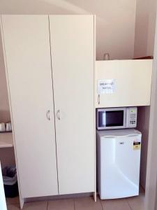 eine Mikrowelle auf einem Kühlschrank neben einem Schrank in der Unterkunft Walgett Motel in Walgett