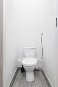 a white toilet in a bathroom with a hose at Rooms4Less in Gdańsk +14 photos