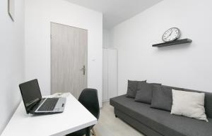 sala de estar con mesa con sofá y ordenador portátil en Rooms4Less, en Gdansk