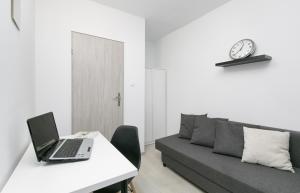a living room with a laptop on a table with a couch at Rooms4Less in Gdańsk