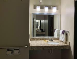 a bathroom with a mirror and a sink at Best Western Plus Great Northern Inn in Havre