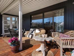un porche cubierto con sofá y mesa en 6 person holiday home in Odder en Norsminde
