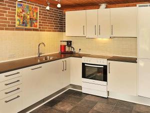 een keuken met witte kasten en een wastafel bij 4 person holiday home in Henne in Henne Strand