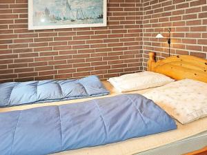 2 bedden in een slaapkamer met een bakstenen muur bij 4 person holiday home in Henne in Henne Strand