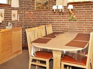 een eetkamer met een tafel en stoelen en een bakstenen muur bij 4 person holiday home in Henne in Henne Strand